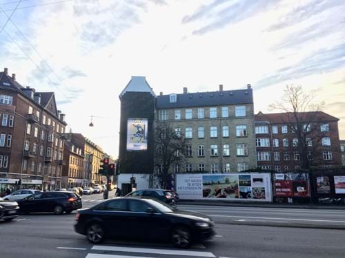 Billede 2: Det trafikale knudepunkt mellem Falkoner Allé og Ågade på Frederiksberg er blevet forskønnet med en grøn væg fra virksomheden Byggros. Væggen finansieres af et reklameskilt – lige nu fra stormagasinet Magasin.