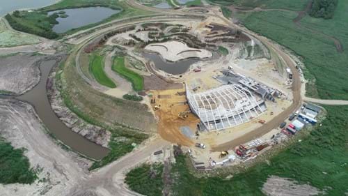 Dronefoto (fra Stauning Maskinstation A/S) af opførelsen af Naturkraft samt jordopfyldningen mod bygningen.
