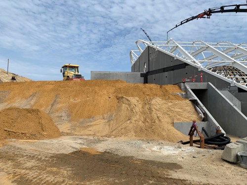 Billede 4: Jordopfyldningen mod bygningen, hvor geoarmeringsnet, sandfyld og en drænende komprimerbar isolering ligger lag på lag.